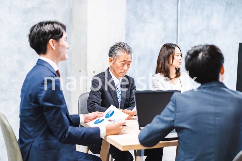商品企画のプレゼンテーションを聞くビジネスパーソン