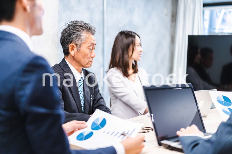 商品企画のプレゼンテーションを聞くビジネスパーソン