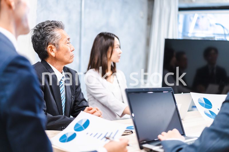 商品企画のプレゼンテーションを聞くビジネスパーソン