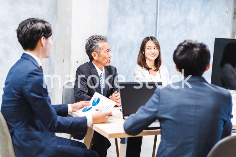 商品企画のプレゼンテーションを聞くビジネスパーソン