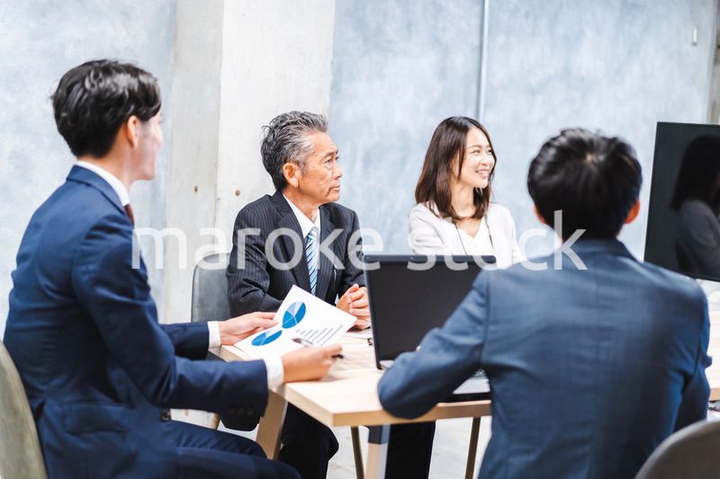 商品企画のプレゼンテーションを聞くビジネスパーソン