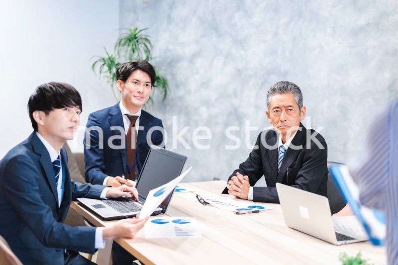 商品企画のプレゼンテーションを聞くビジネスパーソン