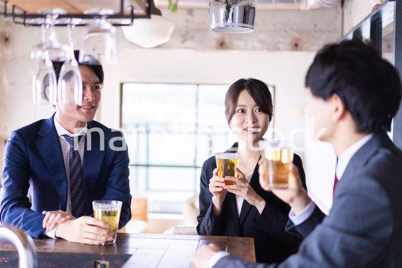 バーでお酒を飲む男女の会社員