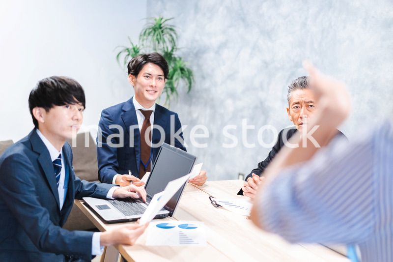 商品企画のプレゼンテーションを聞くビジネスパーソン