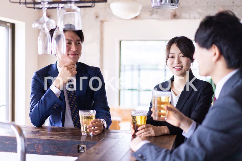 バーでお酒を飲む男女の会社員
