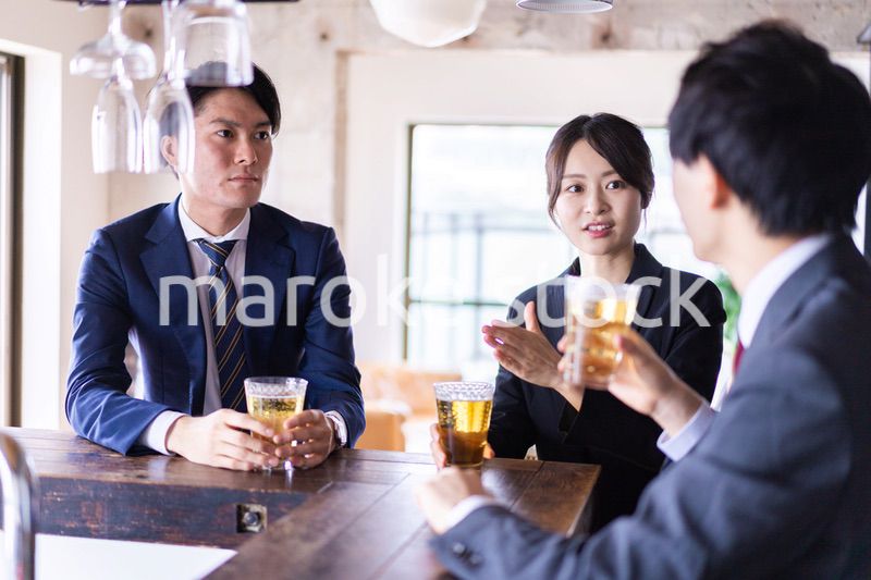 バーでお酒を飲む男女の会社員