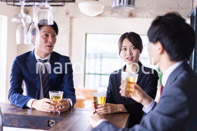 バーでお酒を飲む男女の会社員