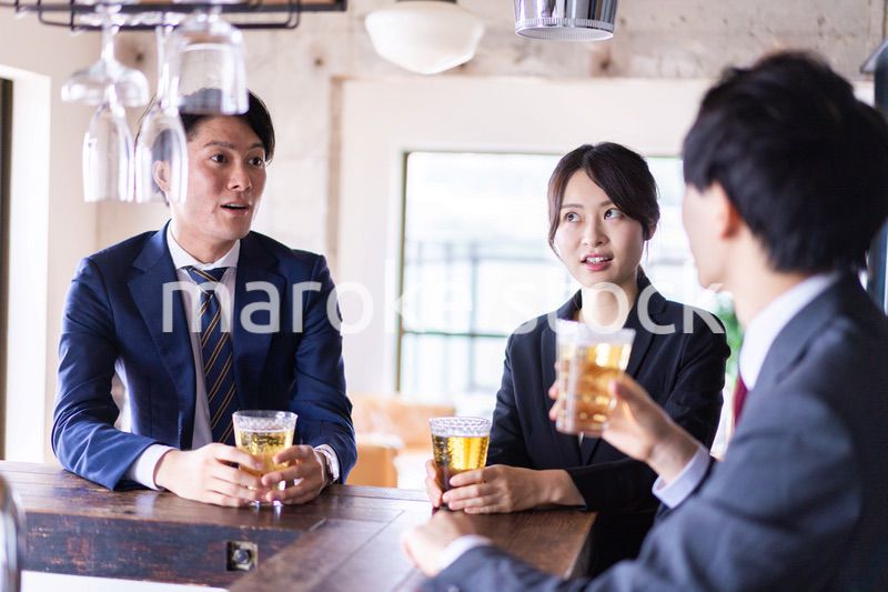 バーでお酒を飲む男女の会社員