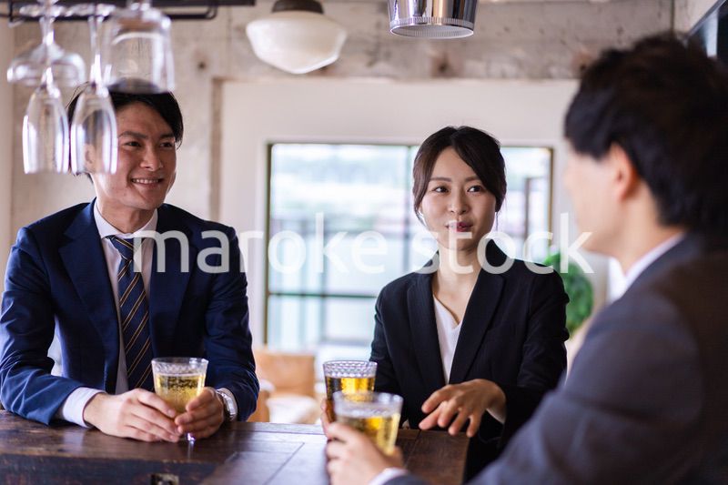 バーでお酒を飲む男女の会社員