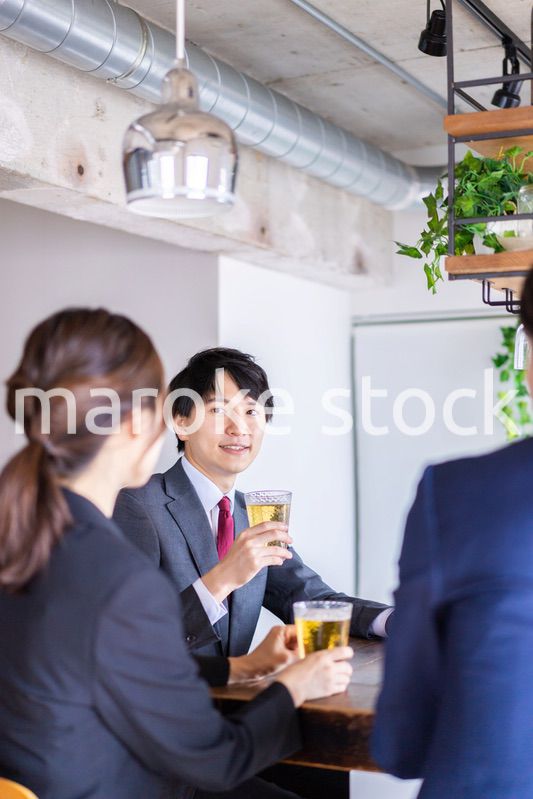お酒を飲みながら話すビジネスパーソン