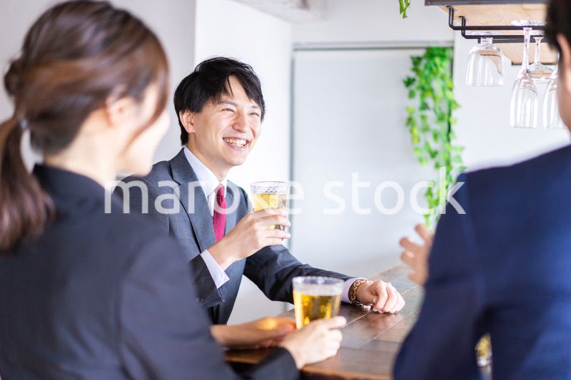 お酒を飲みながら話すビジネスパーソン