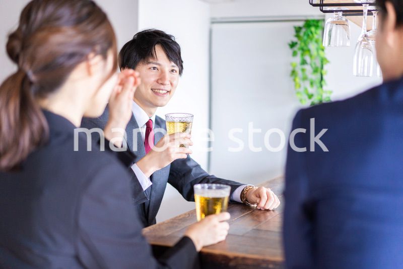 お酒を飲みながら話すビジネスパーソン