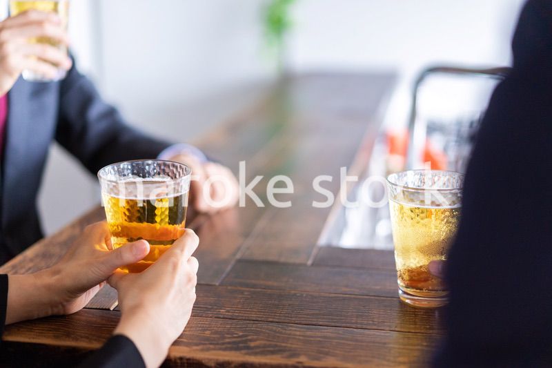 お酒を飲みながら話すビジネスパーソン