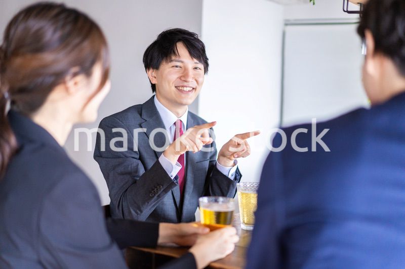 お酒を飲みながら話すビジネスパーソン