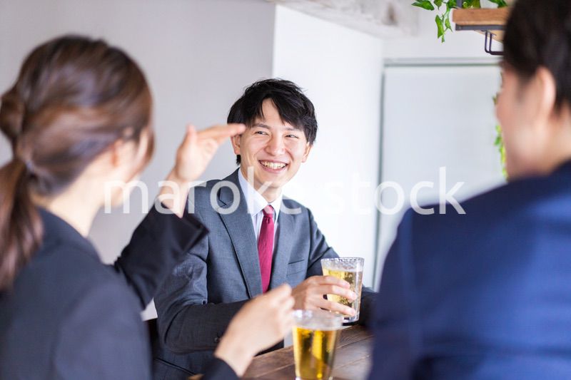 お酒を飲みながら話すビジネスパーソン