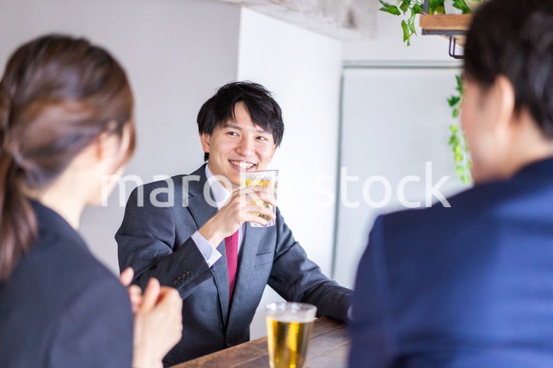 お酒を飲みながら話すビジネスパーソン