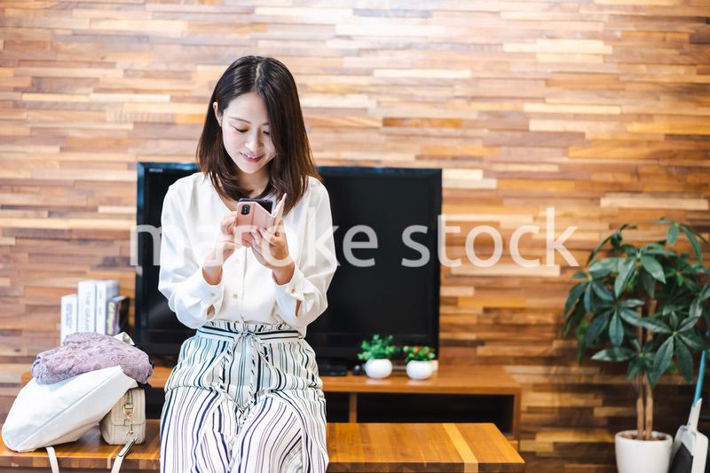 リビングでスマホを使う主婦