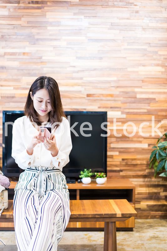 リビングでスマホを使う主婦