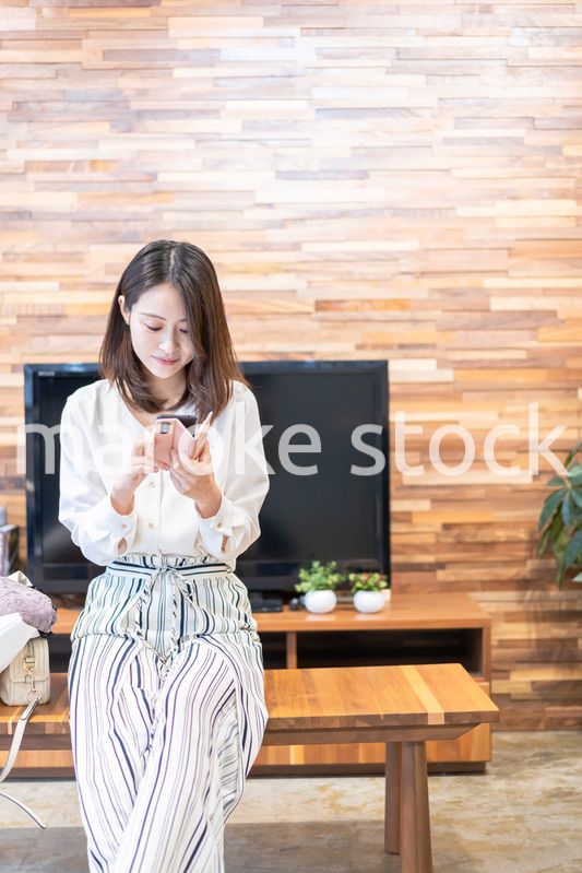 リビングでスマホを使う主婦