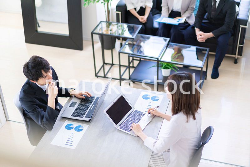 明るいオフィスでミーティングをするビジネスパーソン