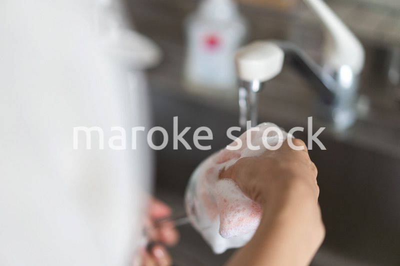 家で洗い物をする若い女性