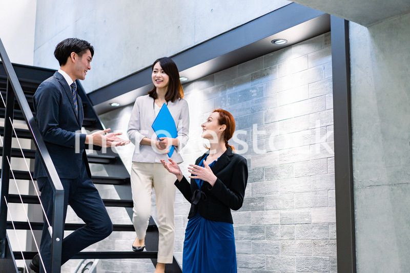 オフィスの階段で話をするビジネスパーソン