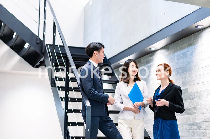 オフィスの階段で話をするビジネスパーソン