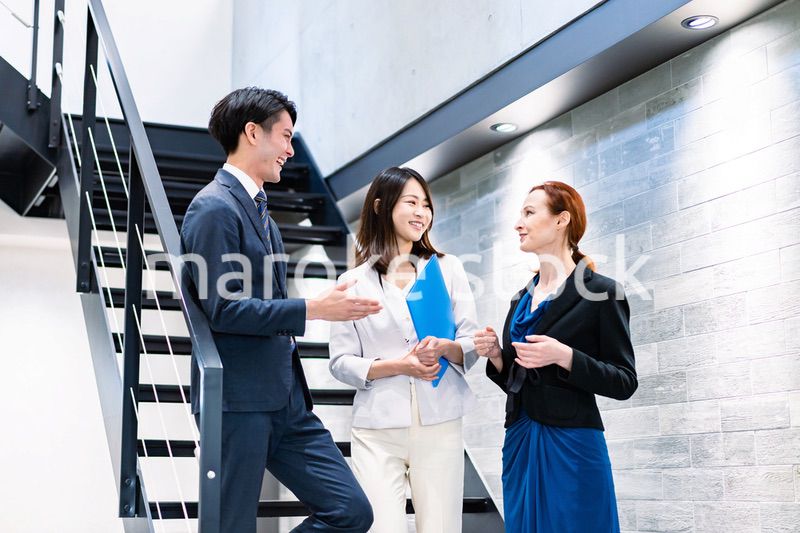 オフィスの階段で話をするビジネスパーソン