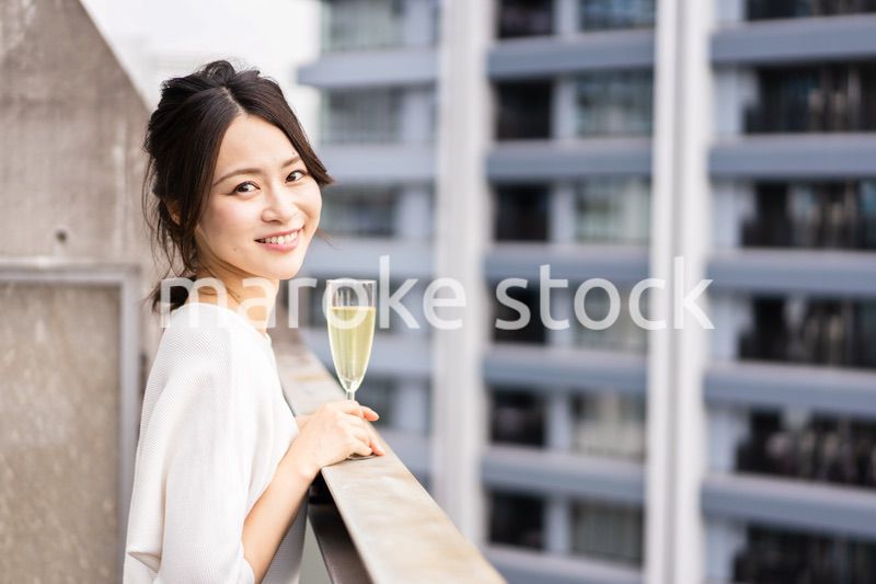 ペントハウスでワインを愉しむリッチな女性