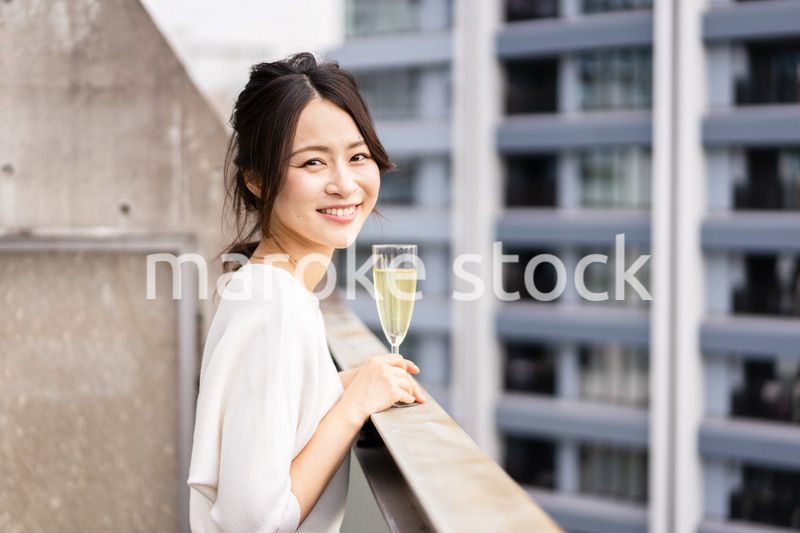 ペントハウスでワインを愉しむリッチな女性