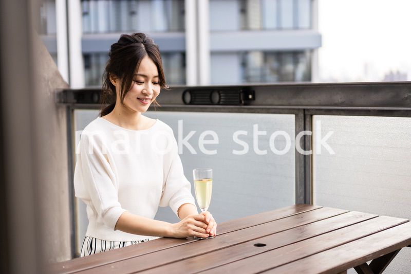 ペントハウスでワインを愉しむリッチな女性