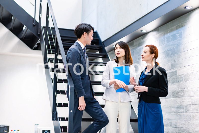 オフィスの階段で話をするビジネスパーソン