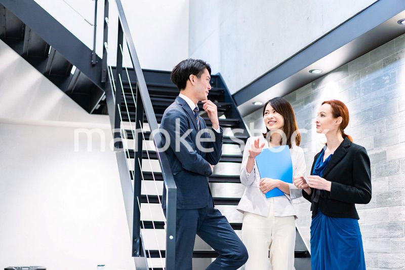オフィスの階段で話をするビジネスパーソン