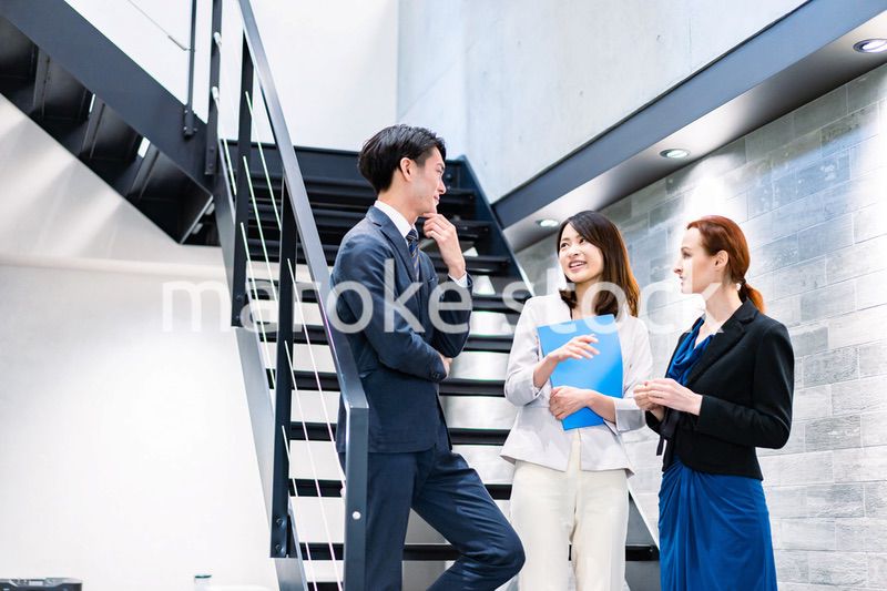 オフィスの階段で話をするビジネスパーソン