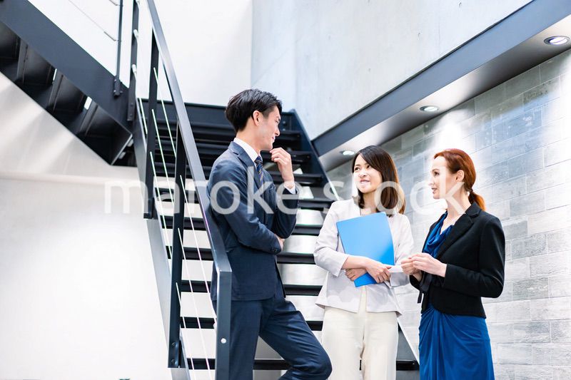 オフィスの階段で話をするビジネスパーソン