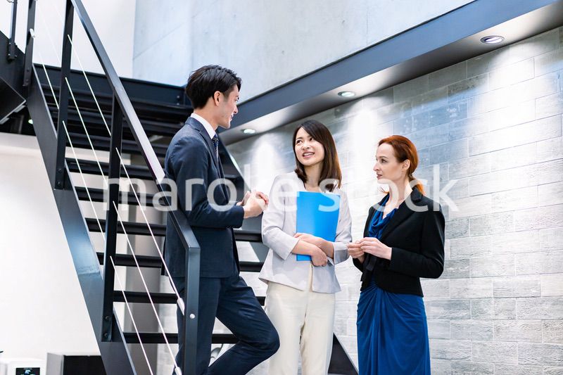 オフィスの階段で話をするビジネスパーソン