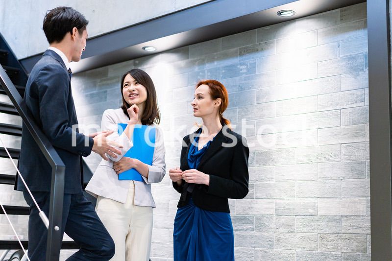 オフィスの階段で話をするビジネスパーソン