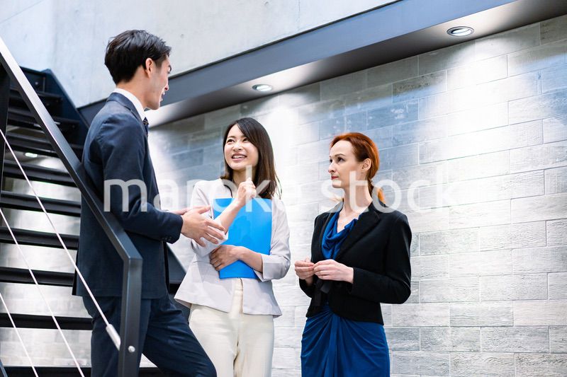 オフィスの階段で話をするビジネスパーソン