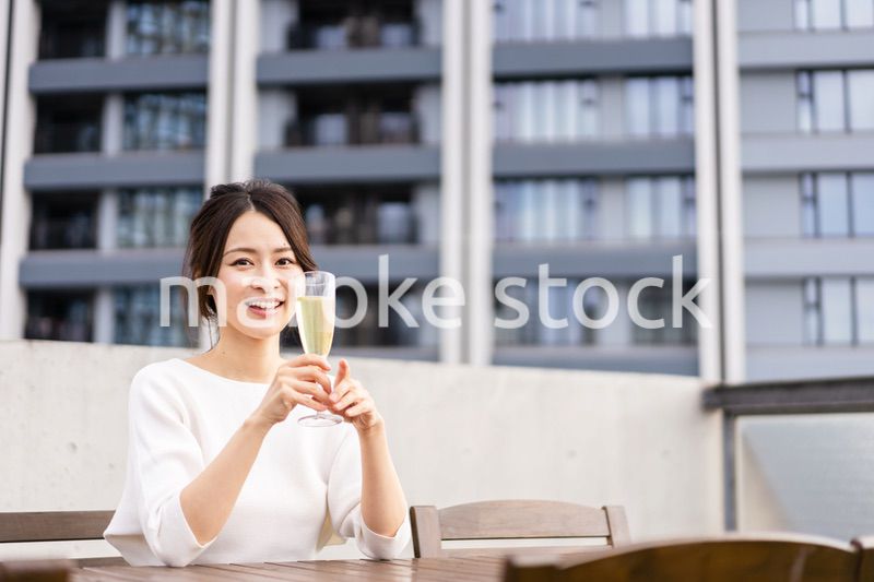 ペントハウスでワインを愉しむリッチな女性