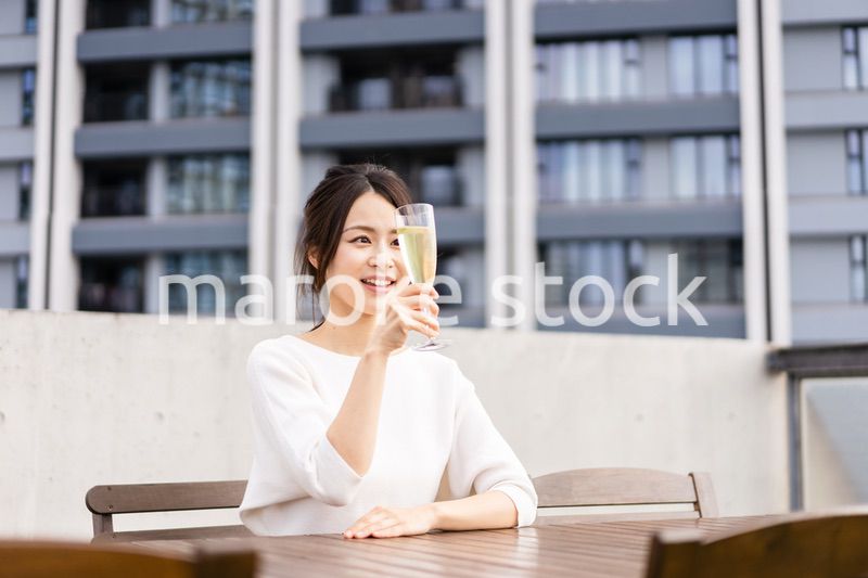 ペントハウスでワインを愉しむリッチな女性