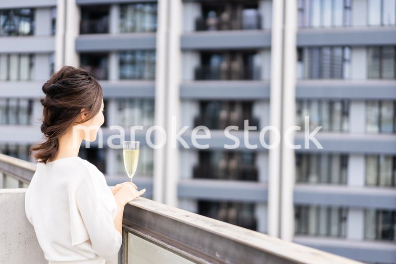 ペントハウスでワインを愉しむリッチな女性