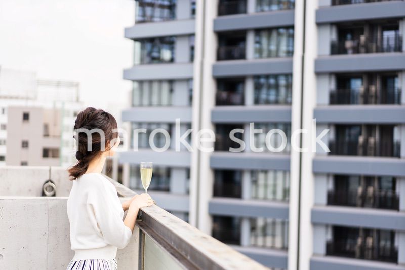 ペントハウスでワインを愉しむリッチな女性