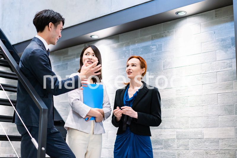 オフィスの階段で話をするビジネスパーソン