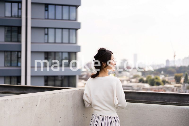 ペントハウスでワインを愉しむリッチな女性