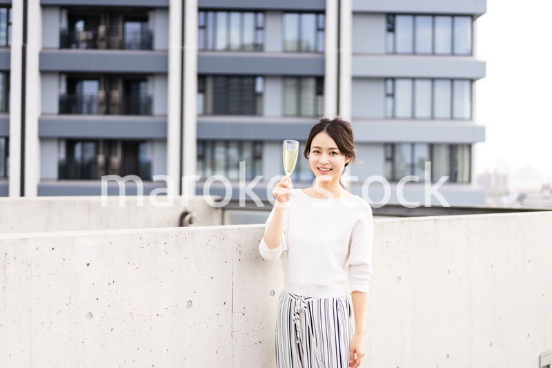 ペントハウスでワインを愉しむリッチな女性