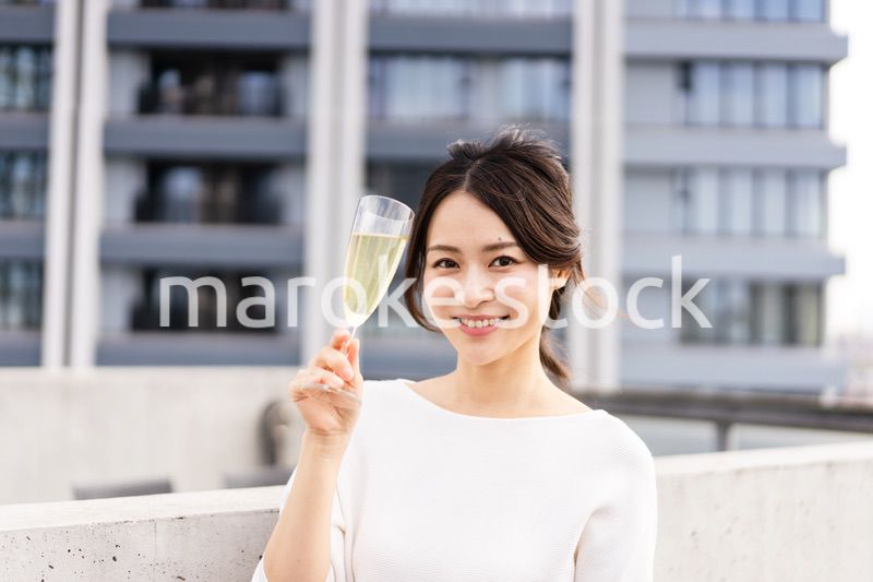 ペントハウスでワインを愉しむリッチな女性