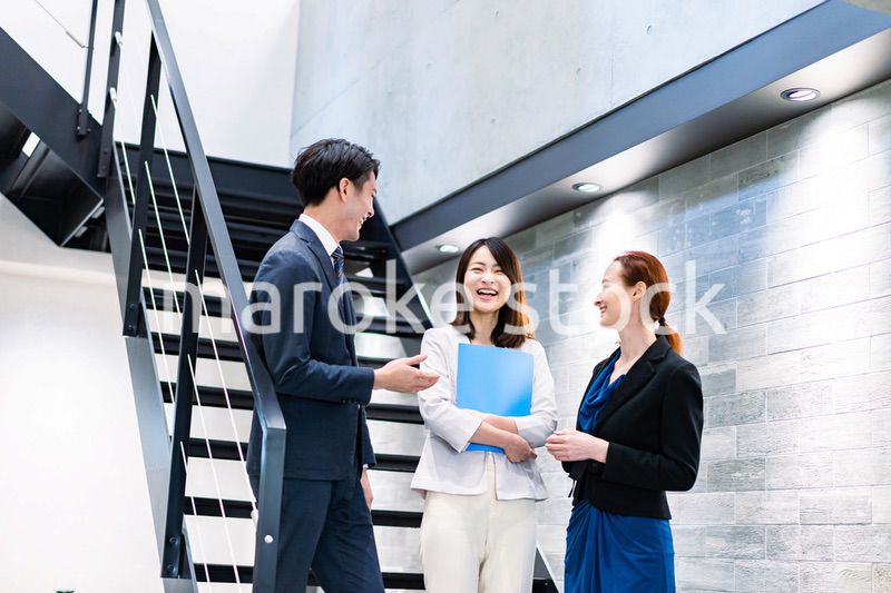 オフィスの階段で話をするビジネスパーソン