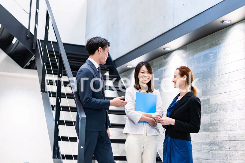オフィスの階段で話をするビジネスパーソン
