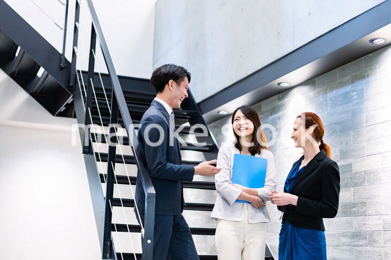 オフィスの階段で話をするビジネスパーソン