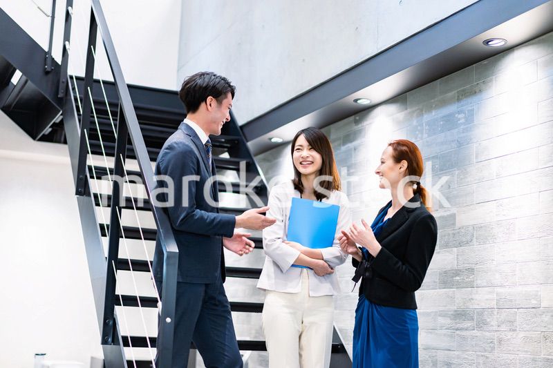 オフィスの階段で話をするビジネスパーソン